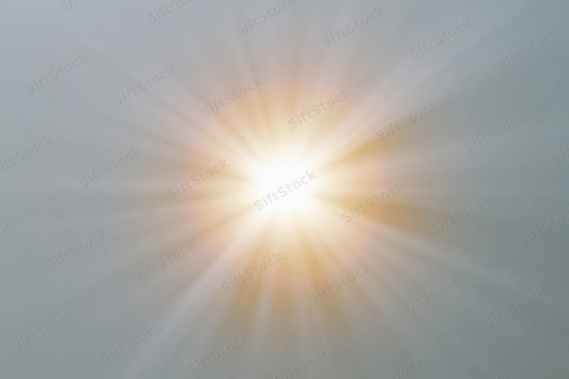 Bright sunburst lens flare radiating light rays from center frame