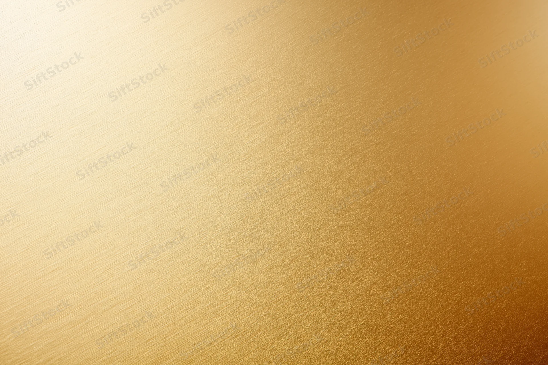 Close-up flat lay of a brushed gold metallic surface filling the frame