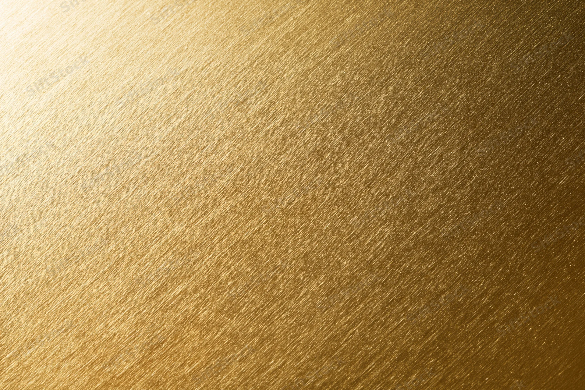 Close-up flat lay of a brushed gold metallic surface filling the frame with diagonal texture and warm gradient tone