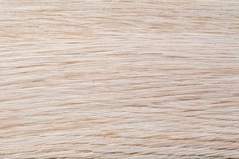 Close-up flat lay of a light bleached oak wood surface showing fine grain texture