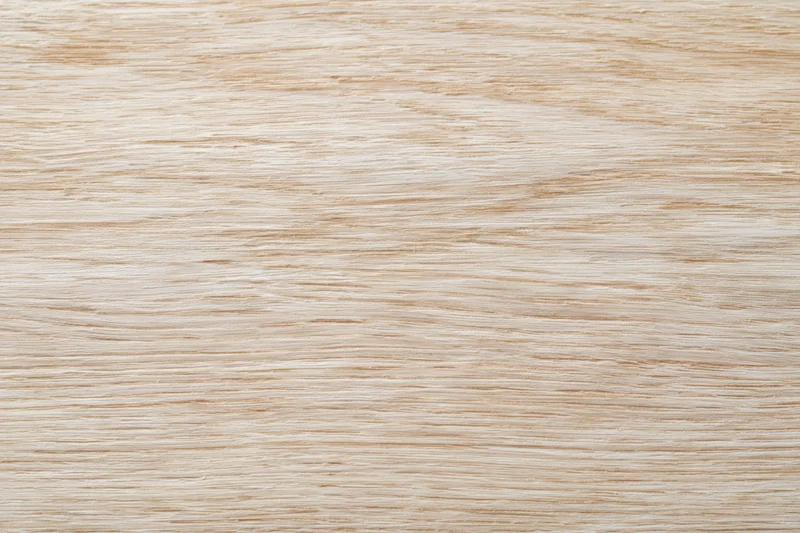 Close-up flat lay of a light bleached oak wood surface showing fine grain texture