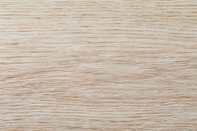 Close-up flat lay of a light bleached oak wood surface showing fine grain texture