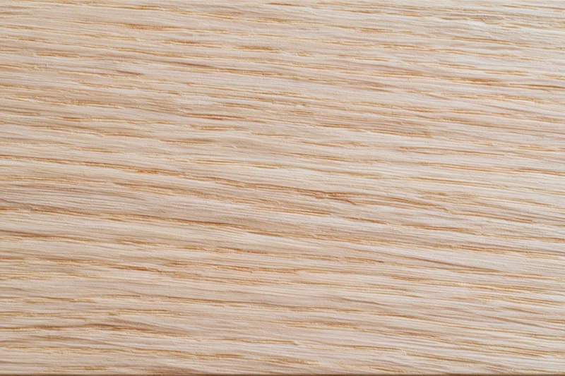 Close-up flat lay of a light bleached oak wood surface showing fine grain texture