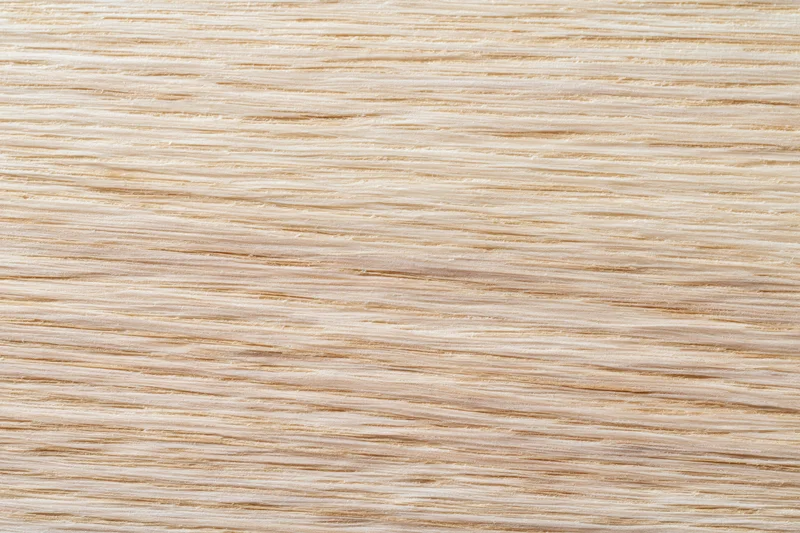 Close-up flat lay of light blonde wood veneer surface showing fine grain texture