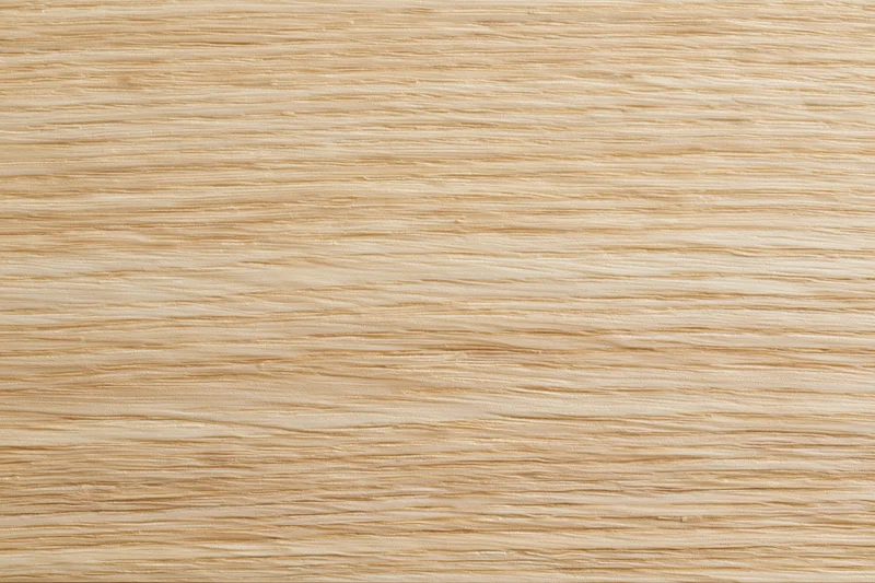 Close-up flat lay of light blonde wood veneer surface showing fine horizontal grain pattern