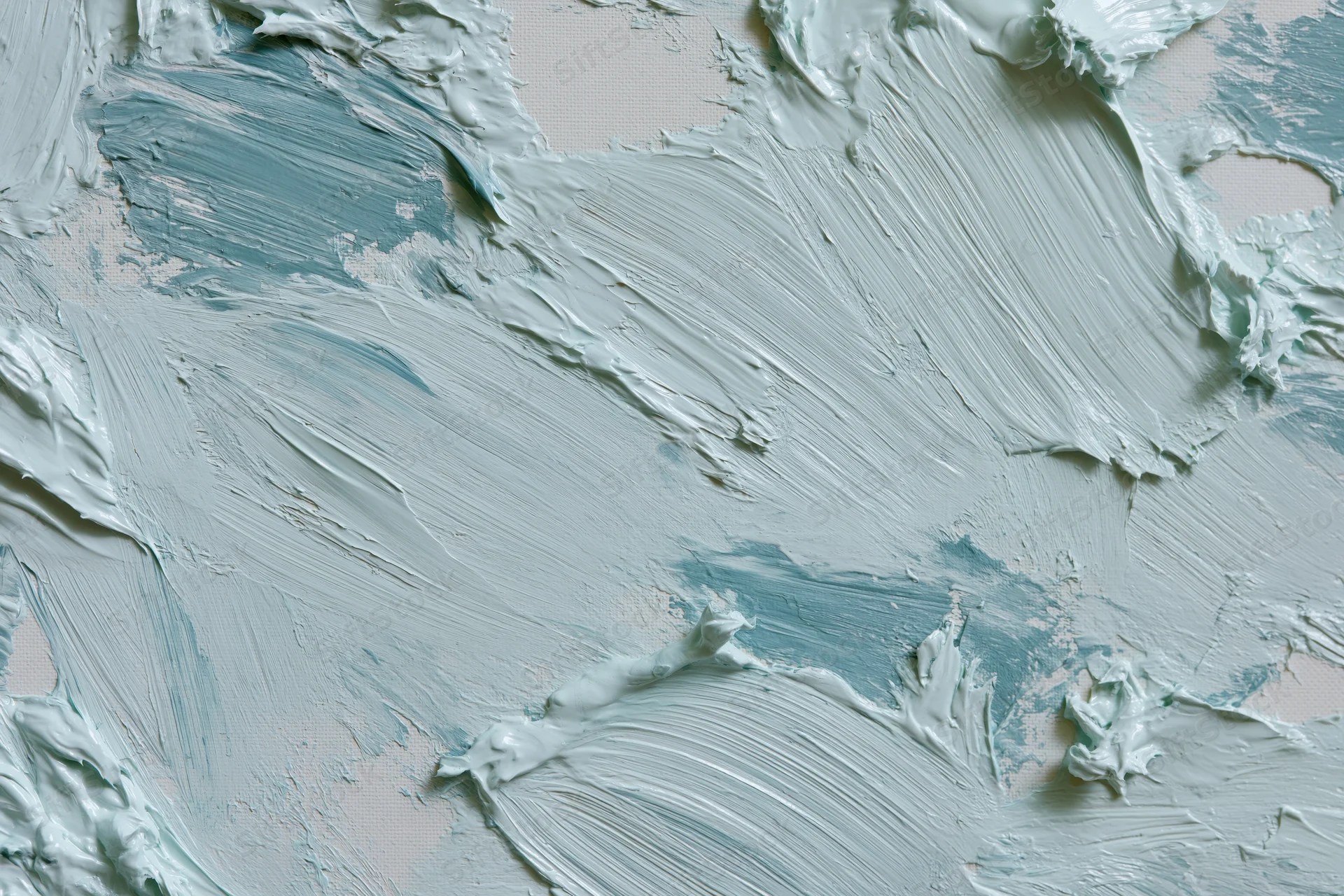 Close-up of white canvas with thick gestural blue and white paint strokes in flat lay arrangement