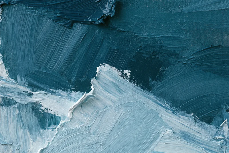 Close-up of textured oil painting surface with blue and white brushstrokes