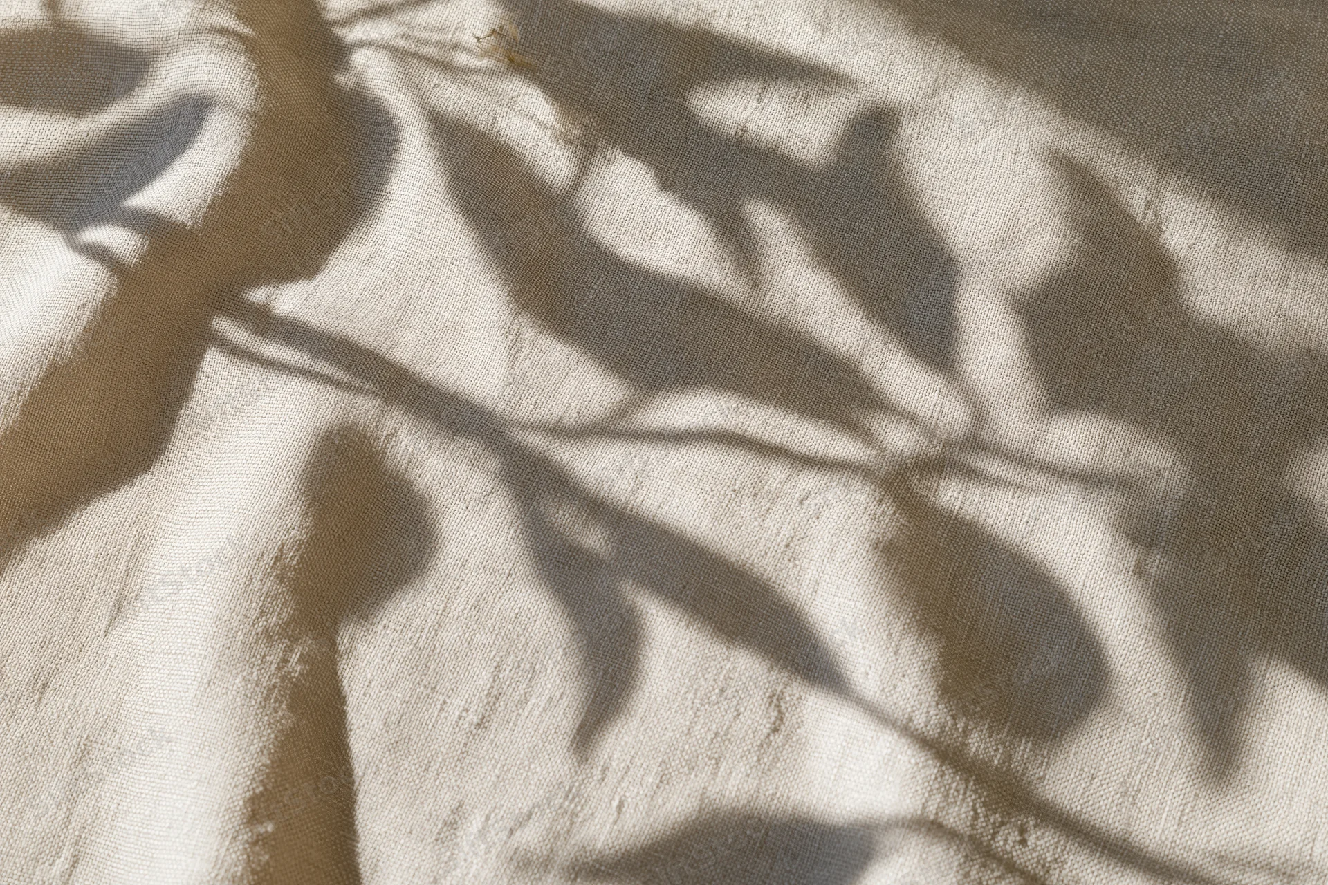 Natural linen fabric with leaf shadows in flat lay arrangement