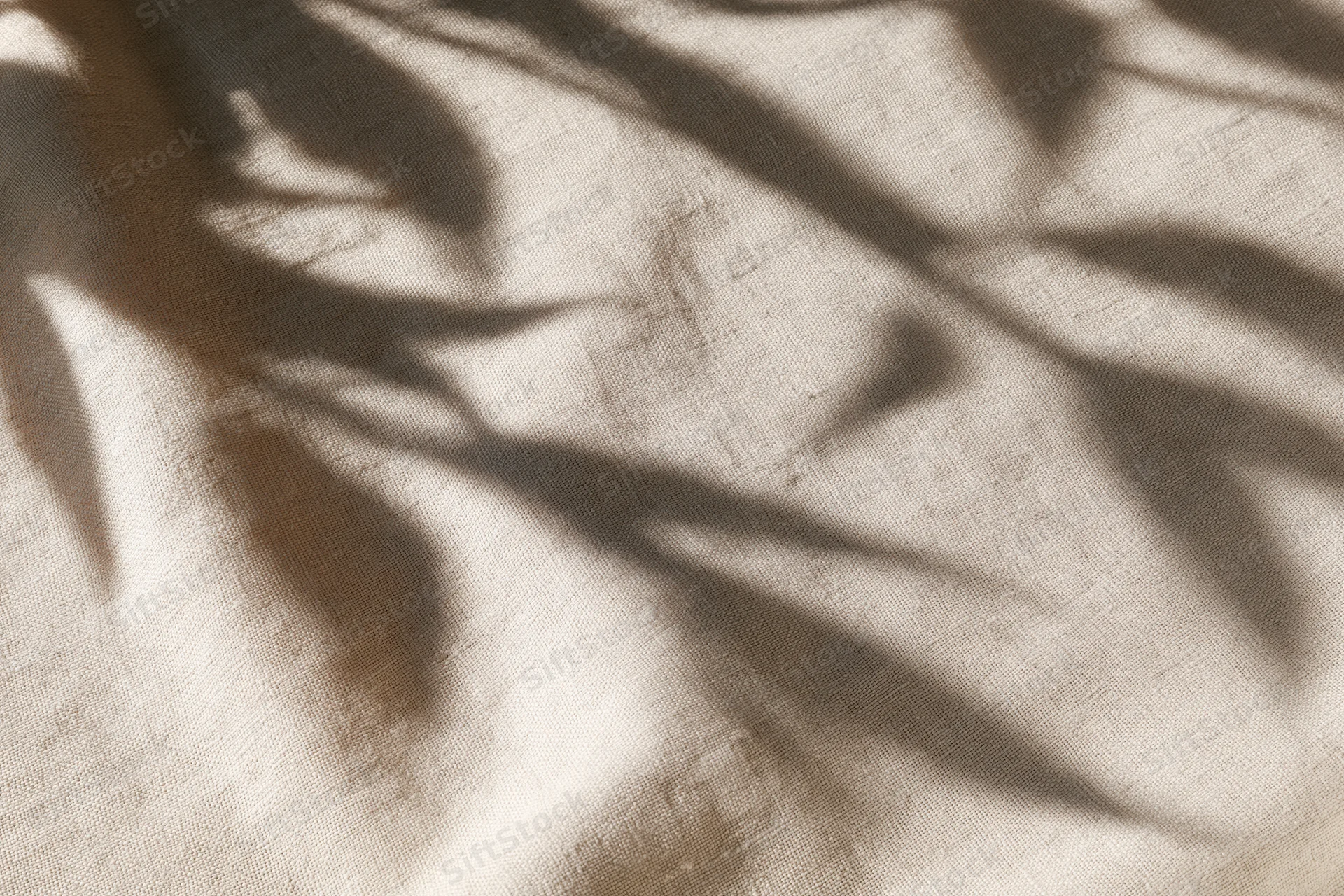 Natural linen fabric with leaf shadows in flat lay arrangement