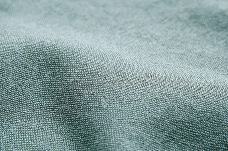 Close-up of plain woven fabric filling the frame with visible texture and subtle color variation