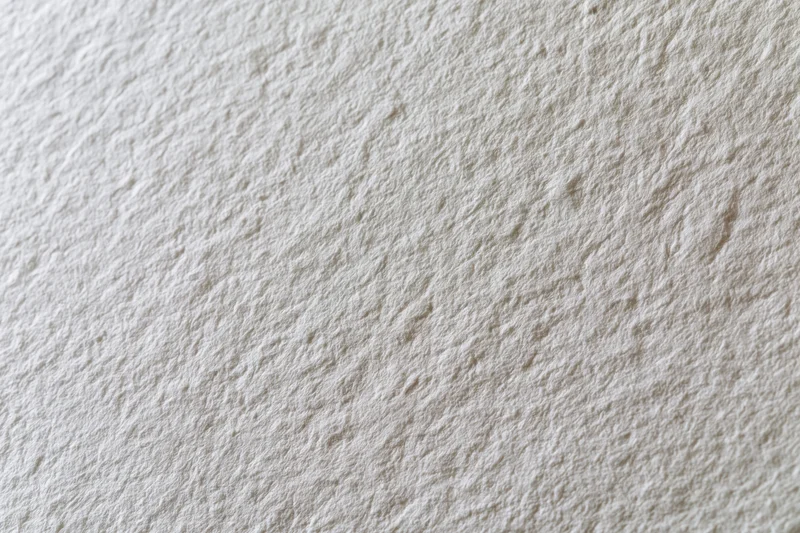 Close-up flat lay of white textured paper surface filling the frame