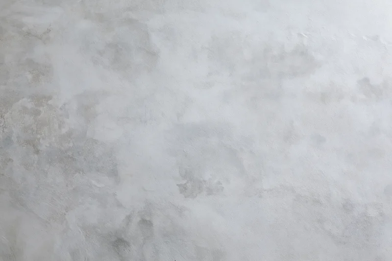 Close-up of a bare concrete wall surface filling the frame with rough texture and gray tones