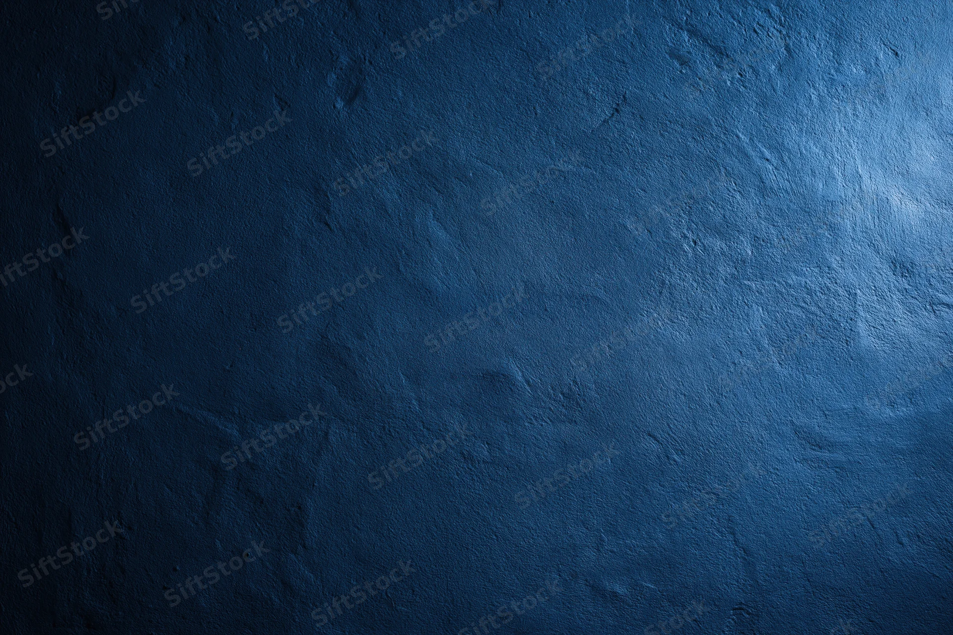 Close-up of a plain painted concrete wall with matte blue finish and textured surface