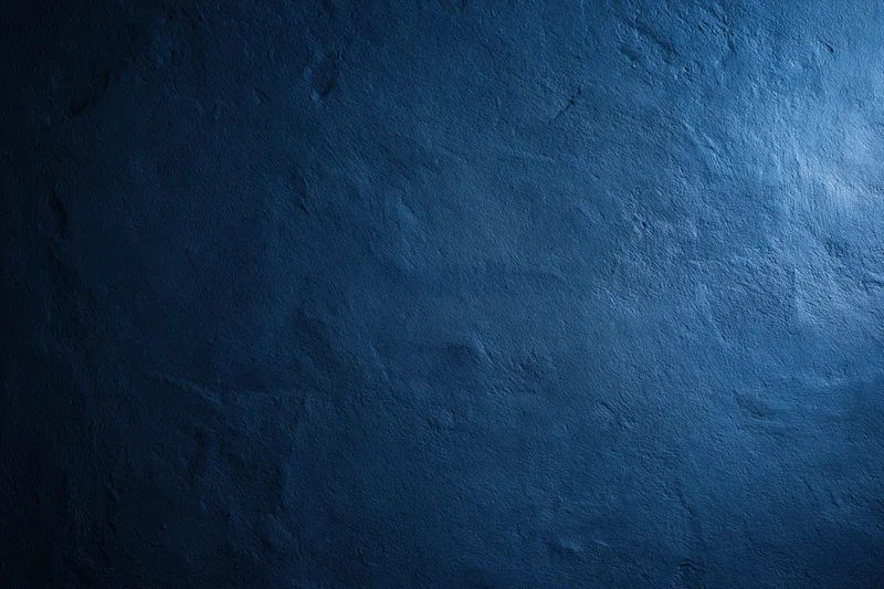 Close-up of a plain painted concrete wall with matte blue finish and textured surface