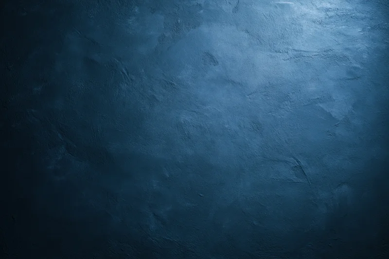 Close-up of a plain painted concrete wall with matte texture and blue-gray tone