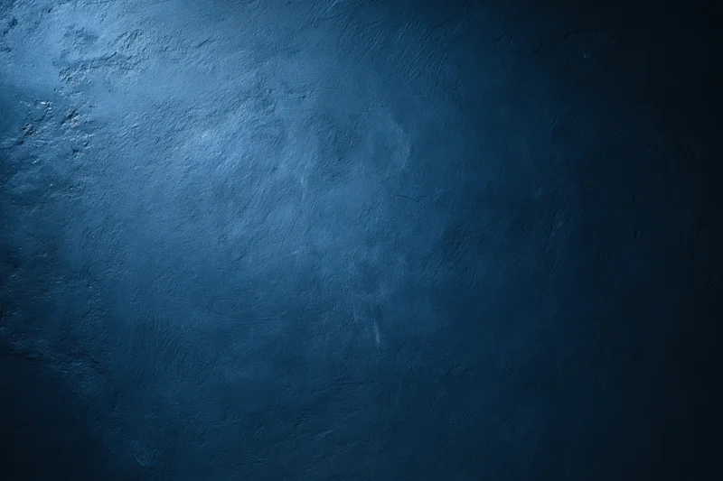 Close-up of a plain painted concrete wall with matte texture and blue tone