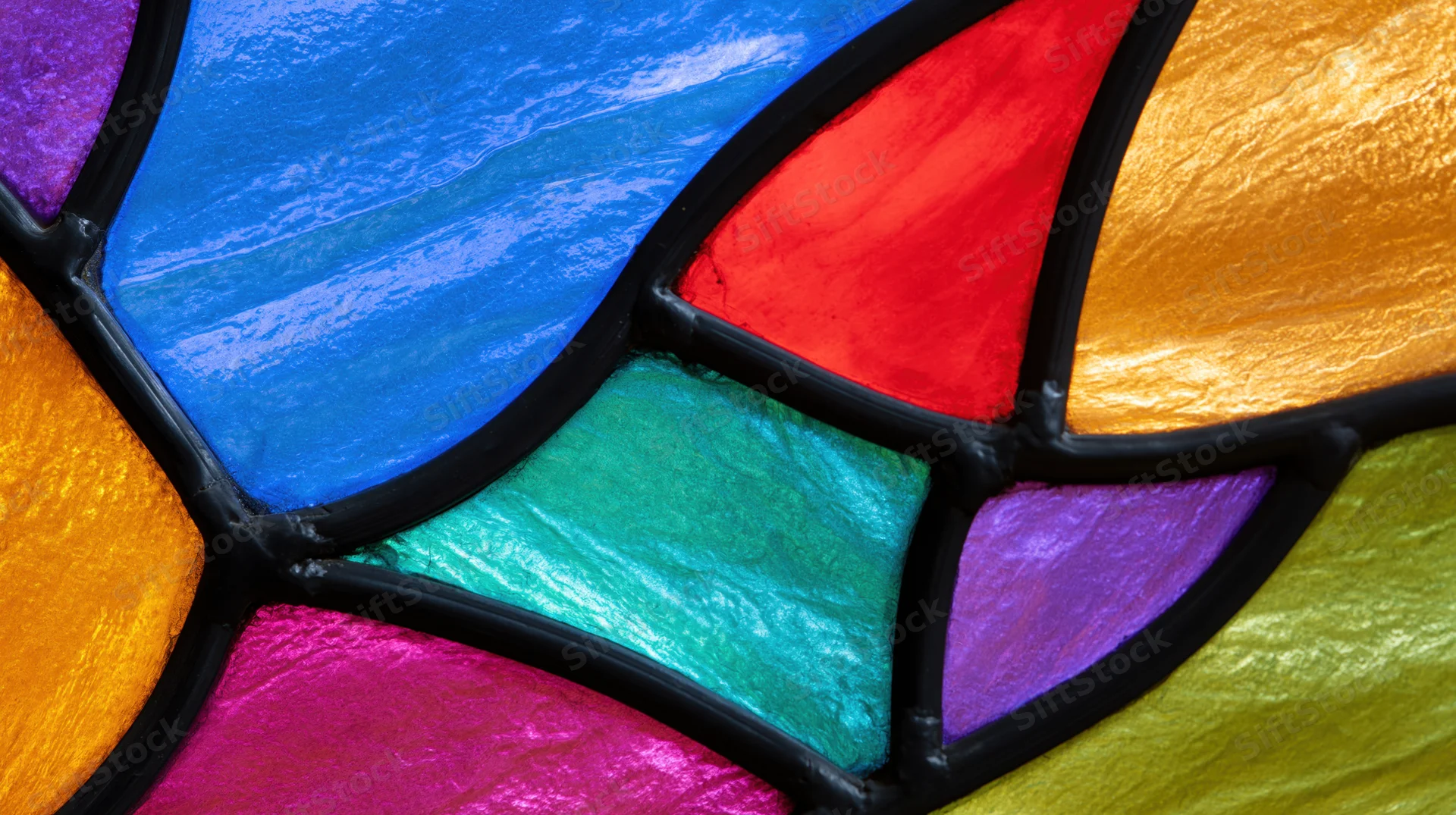 Close-up of colorful gothic arch stained glass window in a church interior