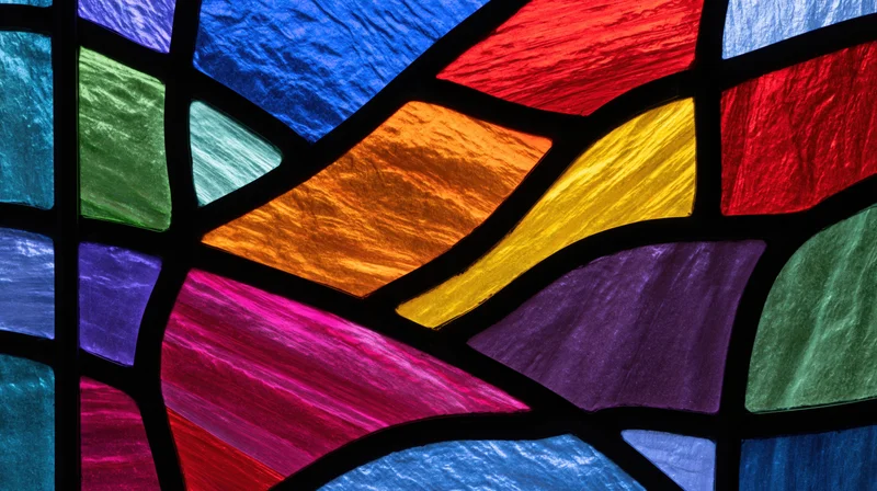 Close-up of colorful stained glass window with gothic arches and leaded glass panels in a church interior