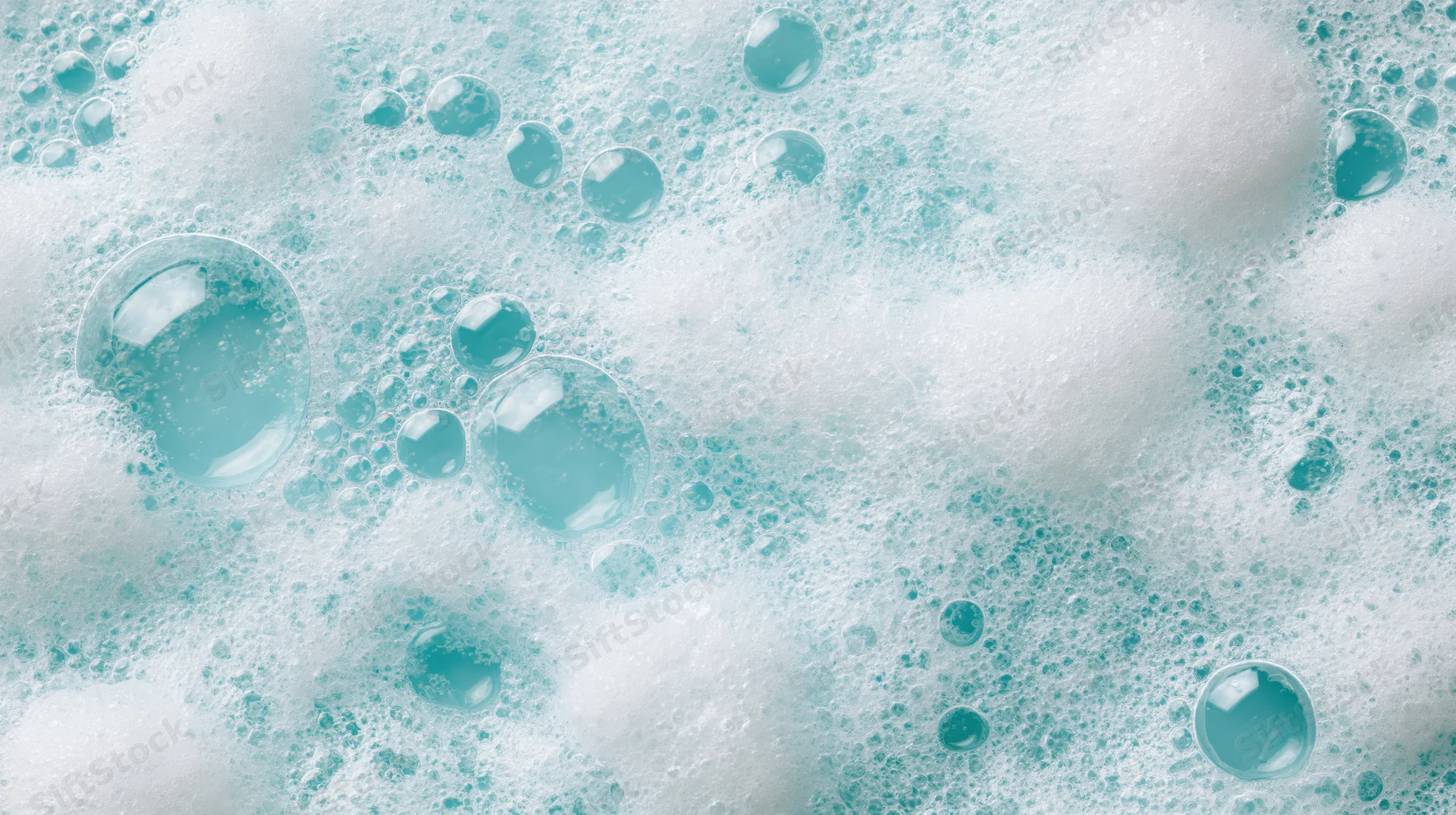 Close-up of white soapy foam and bubbles floating on a liquid surface