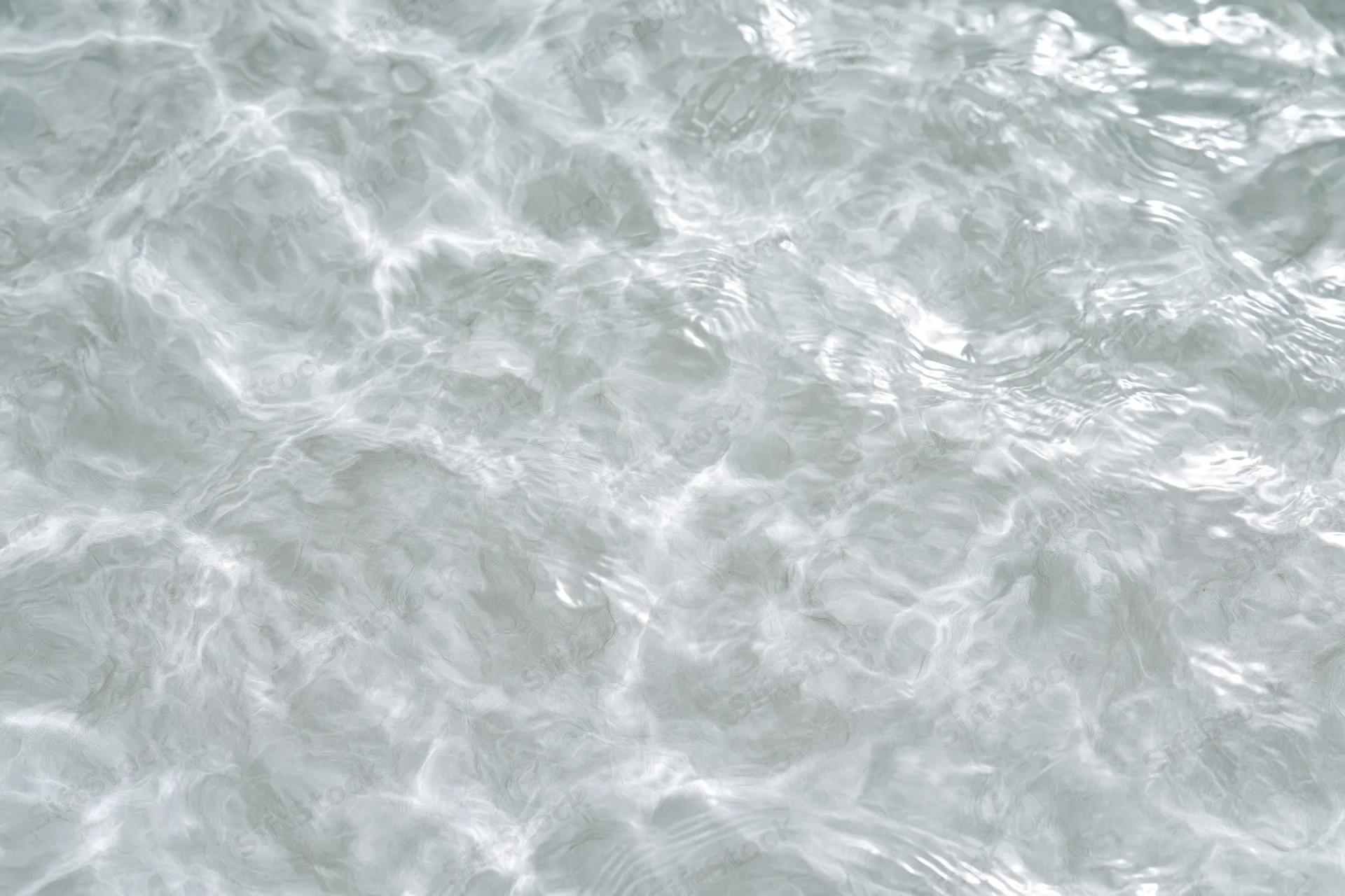 Calm clear water surface with gentle ripples and light reflections