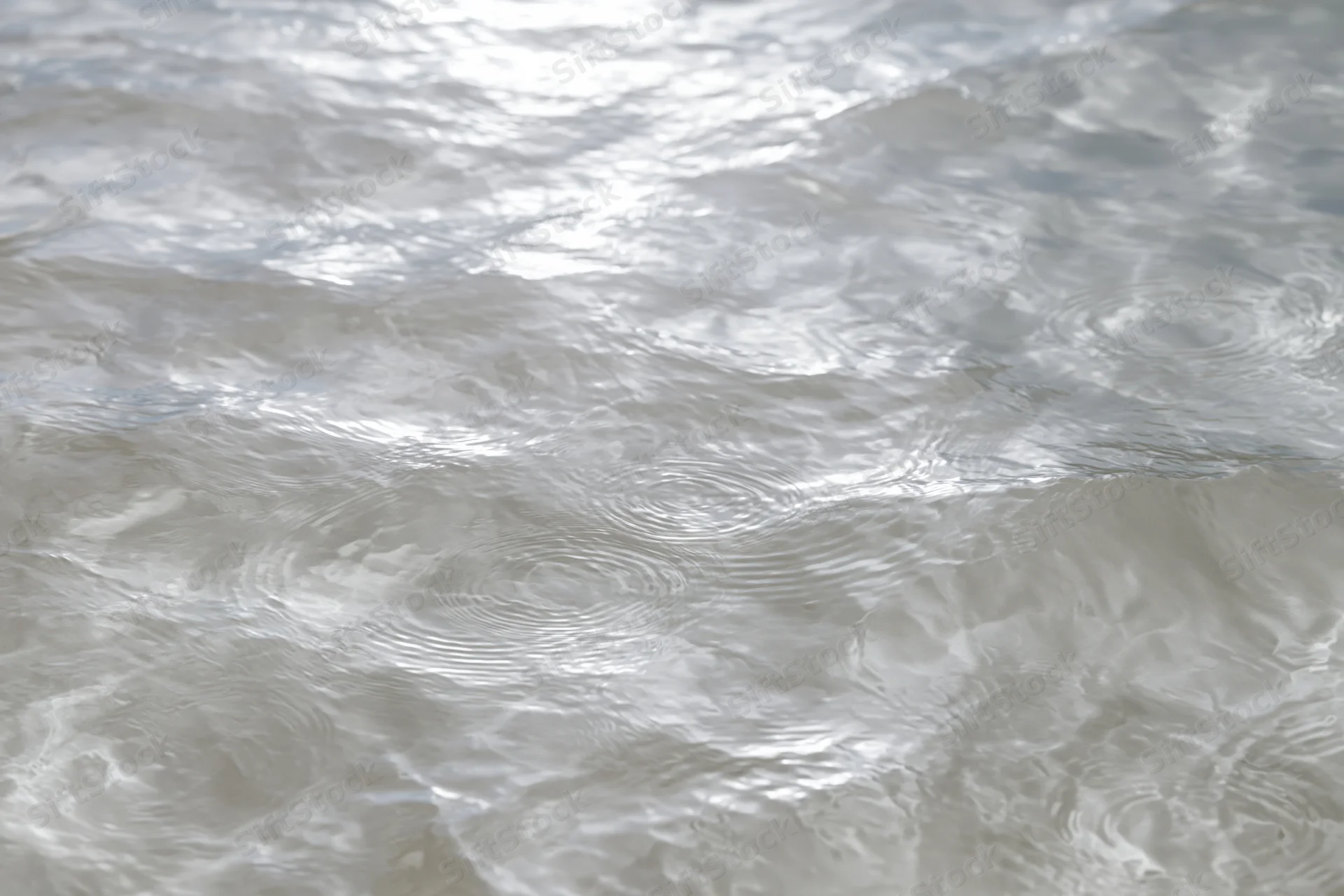 Calm clear water surface with gentle ripples viewed from above