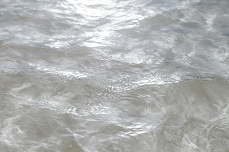 Calm clear water surface with gentle ripples viewed from above