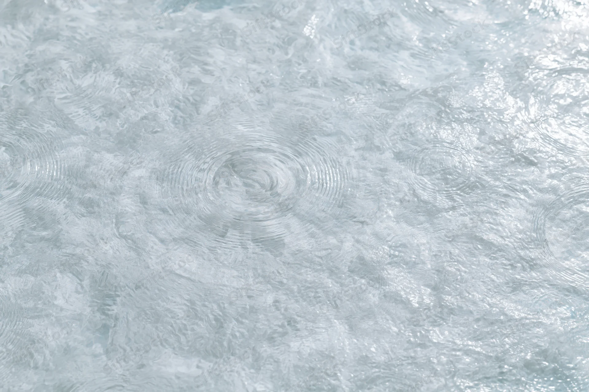 Calm clear water surface with gentle ripples from overhead closeup view