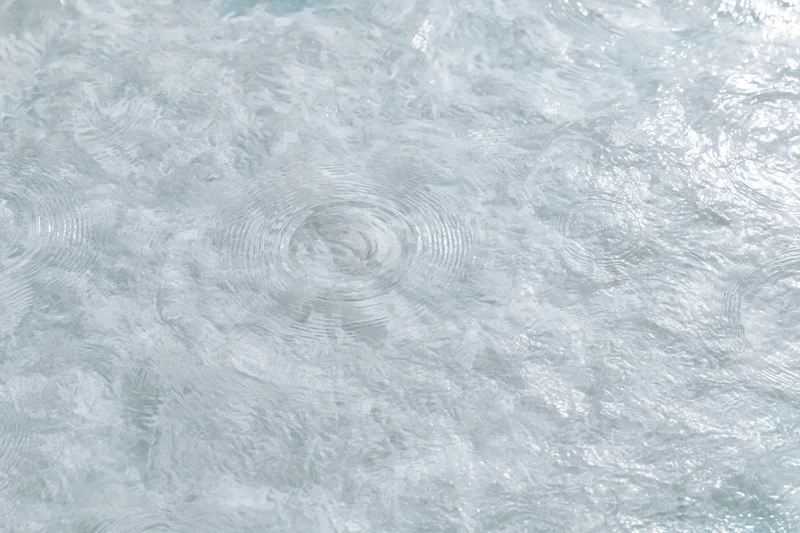 Calm clear water surface with gentle ripples from overhead closeup view