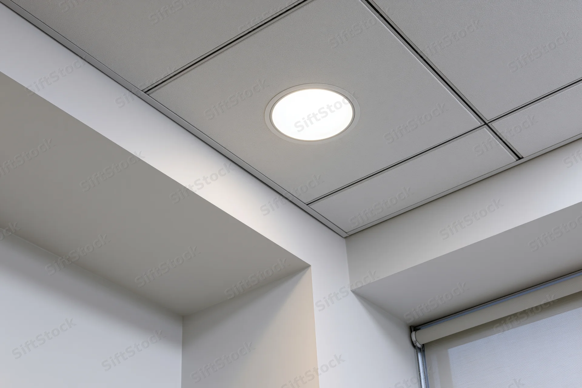 Recessed circular light in a modern office ceiling corner
