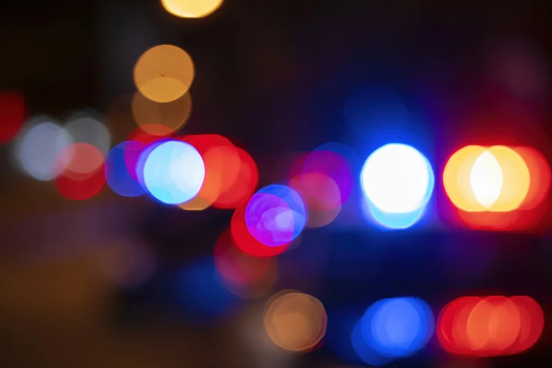 Defocused police emergency lights flashing at night in an urban setting