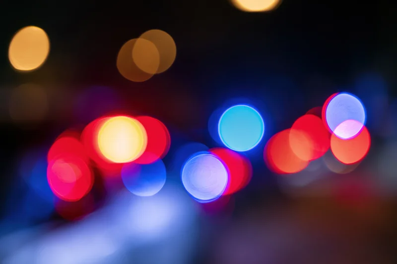 Defocused police emergency lights flashing at night in an urban setting