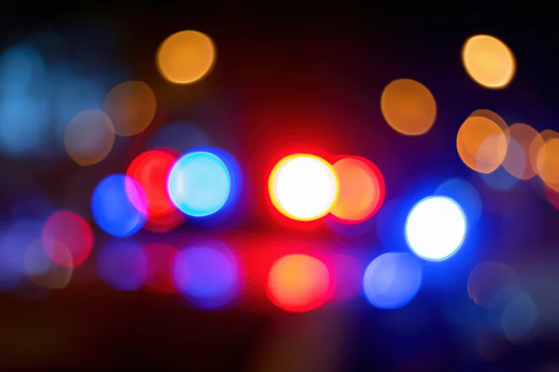 Defocused police emergency lights flashing at night in an urban setting