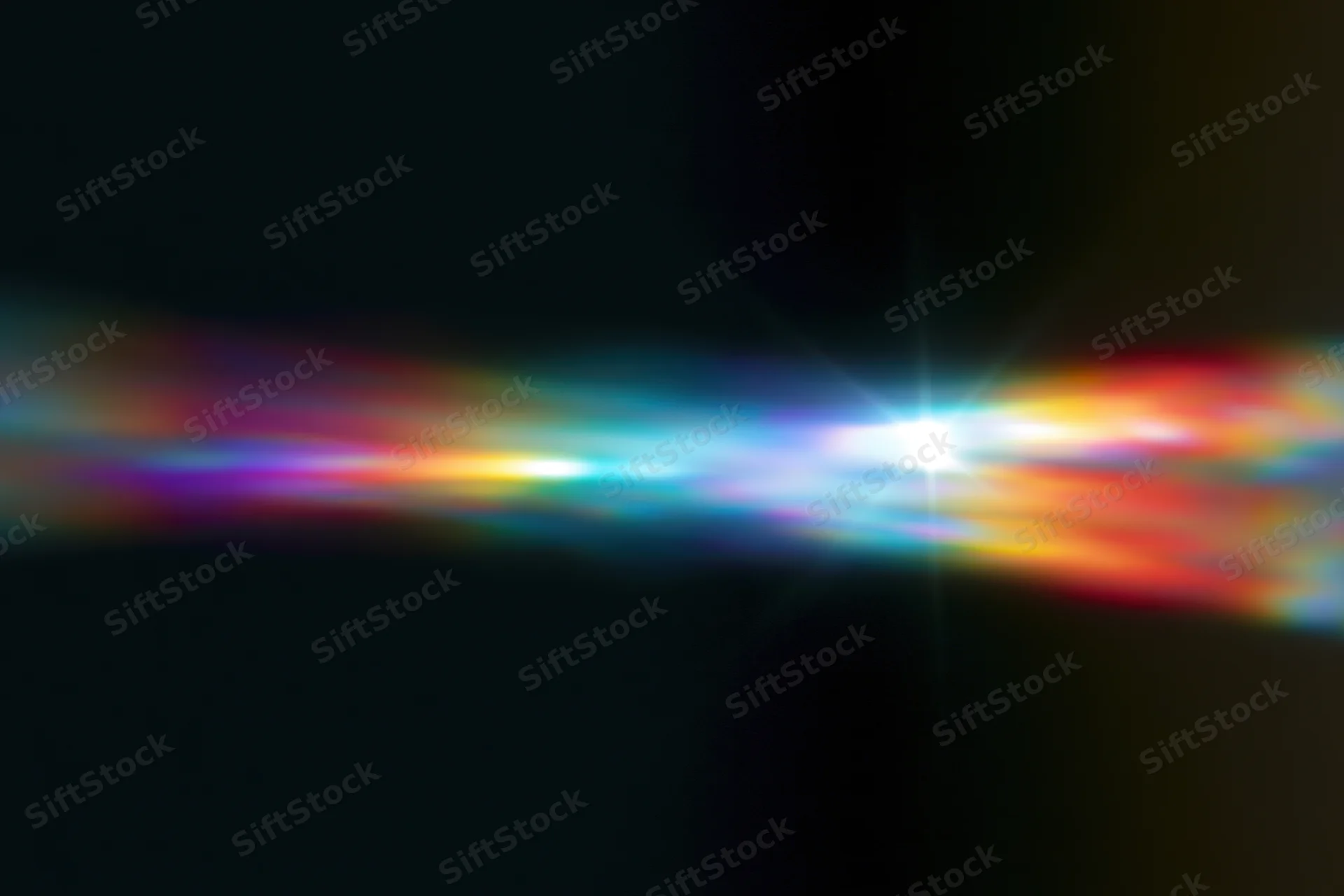 Defocused rainbow light diffraction pattern floating against dark background with central bright glow and color gradient