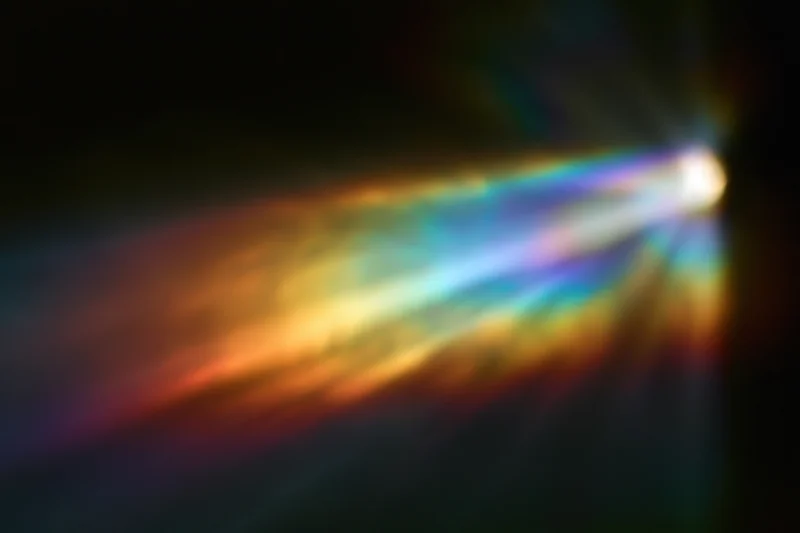 Rainbow light diffraction pattern floating against dark background with soft glow and color gradient