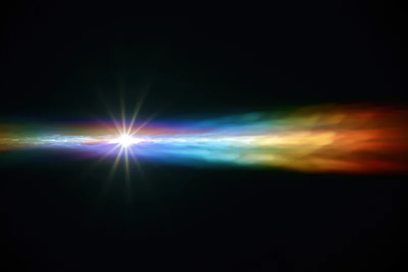 Horizontal rainbow light diffraction pattern glowing against dark background with starburst center
