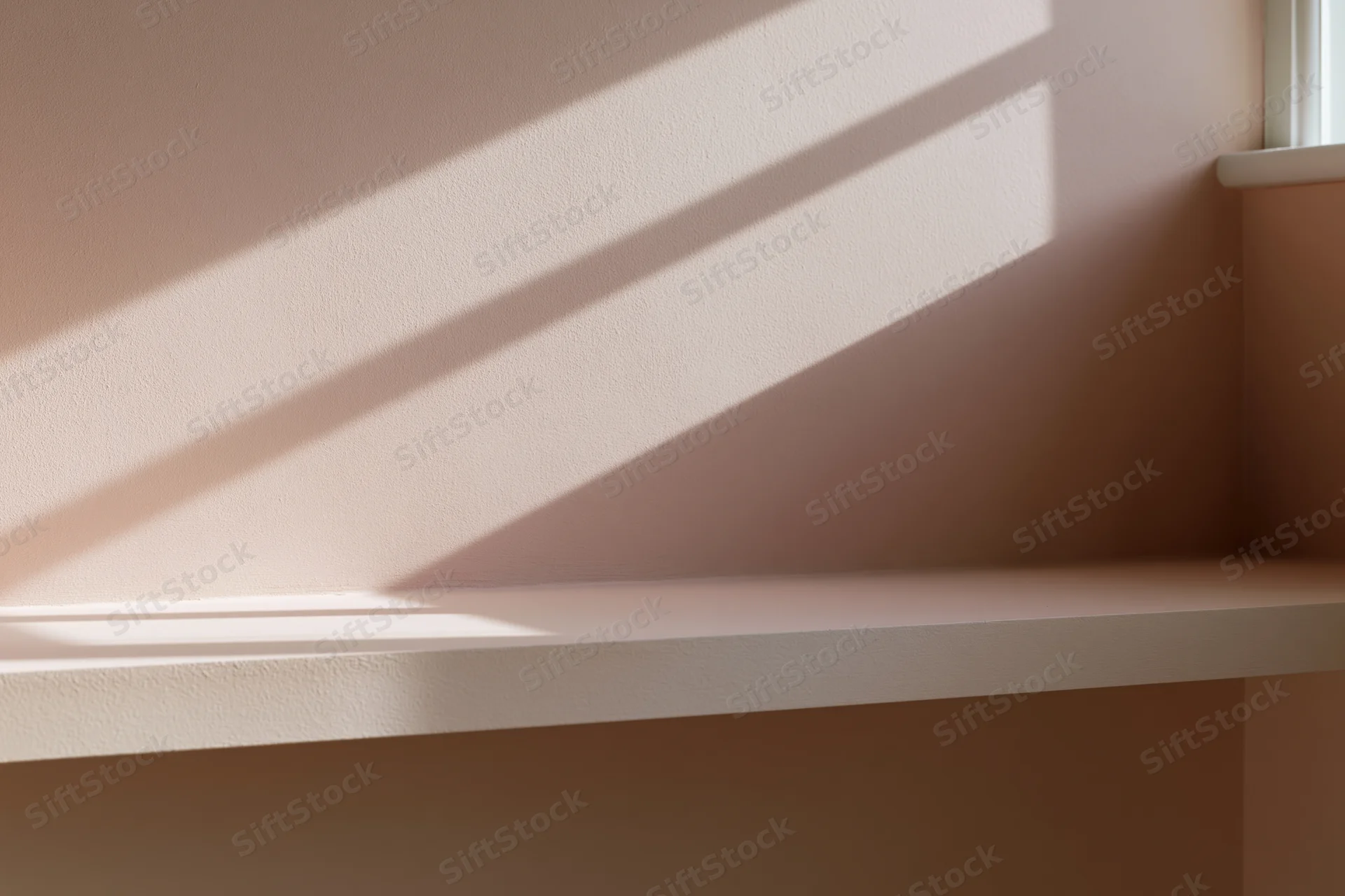Empty minimalist shelf against a flat matte wall with sunlight casting shadows from a window