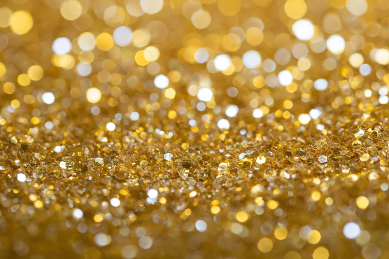 Gold glitter texture with sparkling bokeh effect filling the frame
