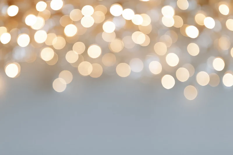 Warm white bokeh lights blurred in soft glow across upper frame with copyspace below