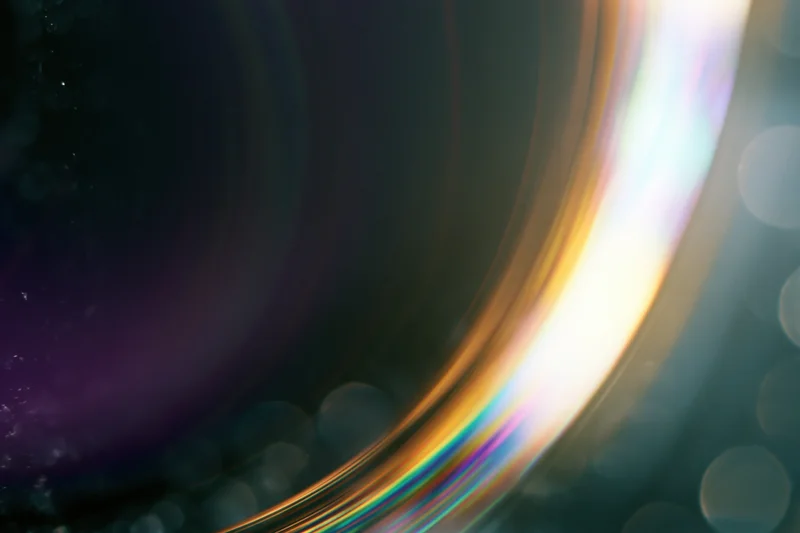 Close-up of a glass sphere reflecting rainbow light with bokeh background