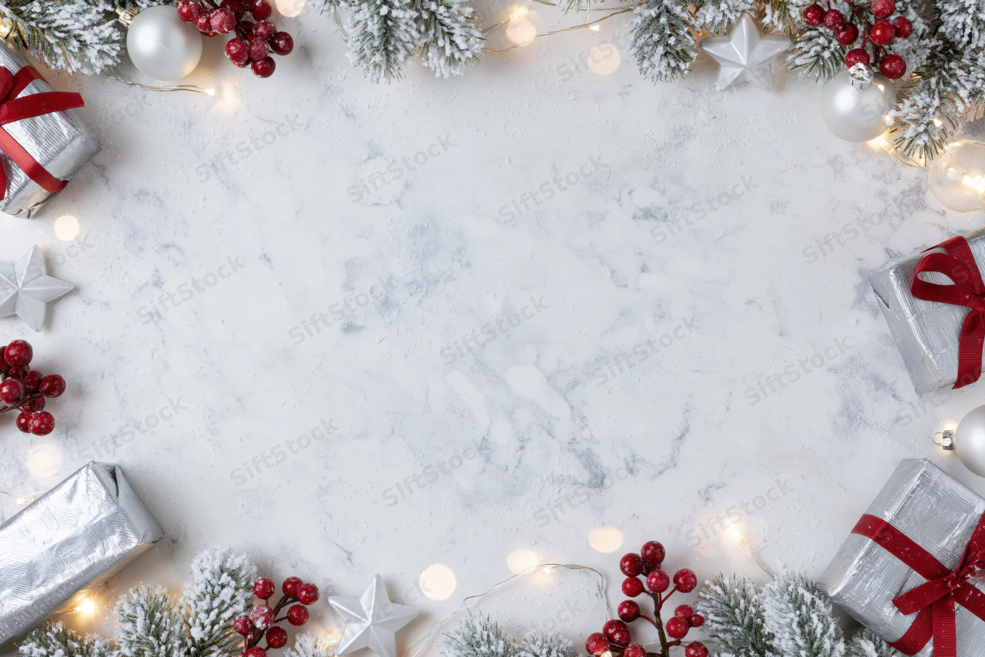 Christmas border frame with decorations and gifts arranged on white marble surface