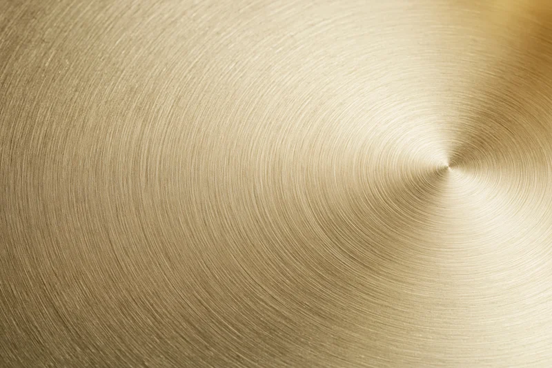 Flat matte gold metallic surface with concentric circular texture filling the frame