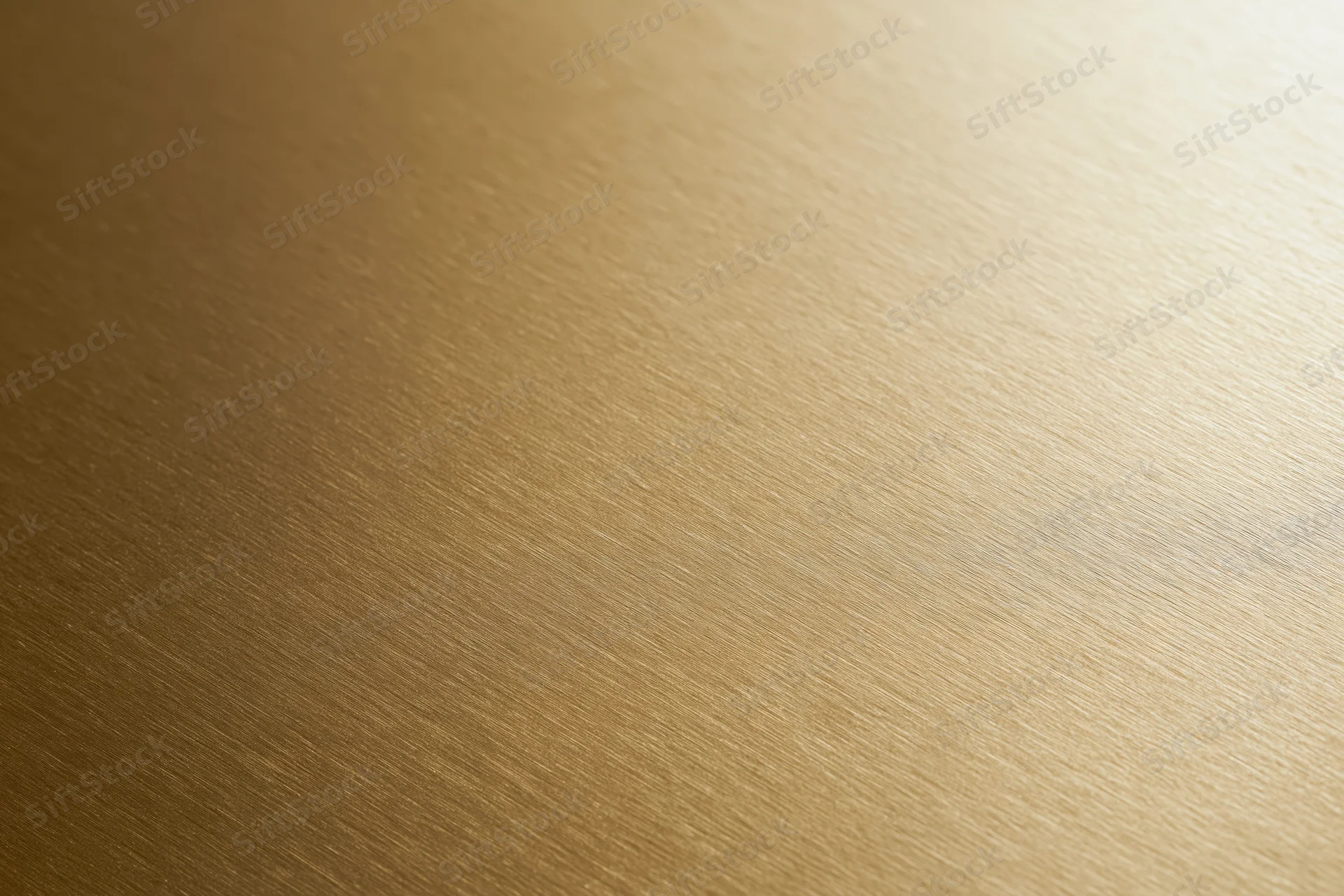 Flat matte gold metallic surface filling the frame with subtle brushed texture and warm light gradient
