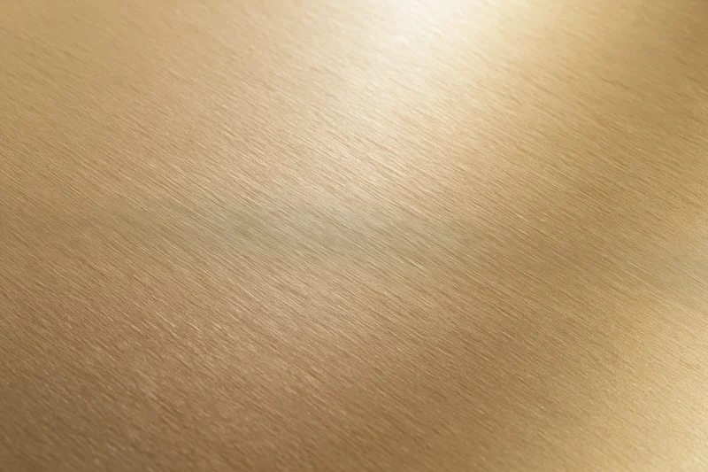 Flat matte gold metallic surface filling the frame with brushed texture and warm gradient lighting