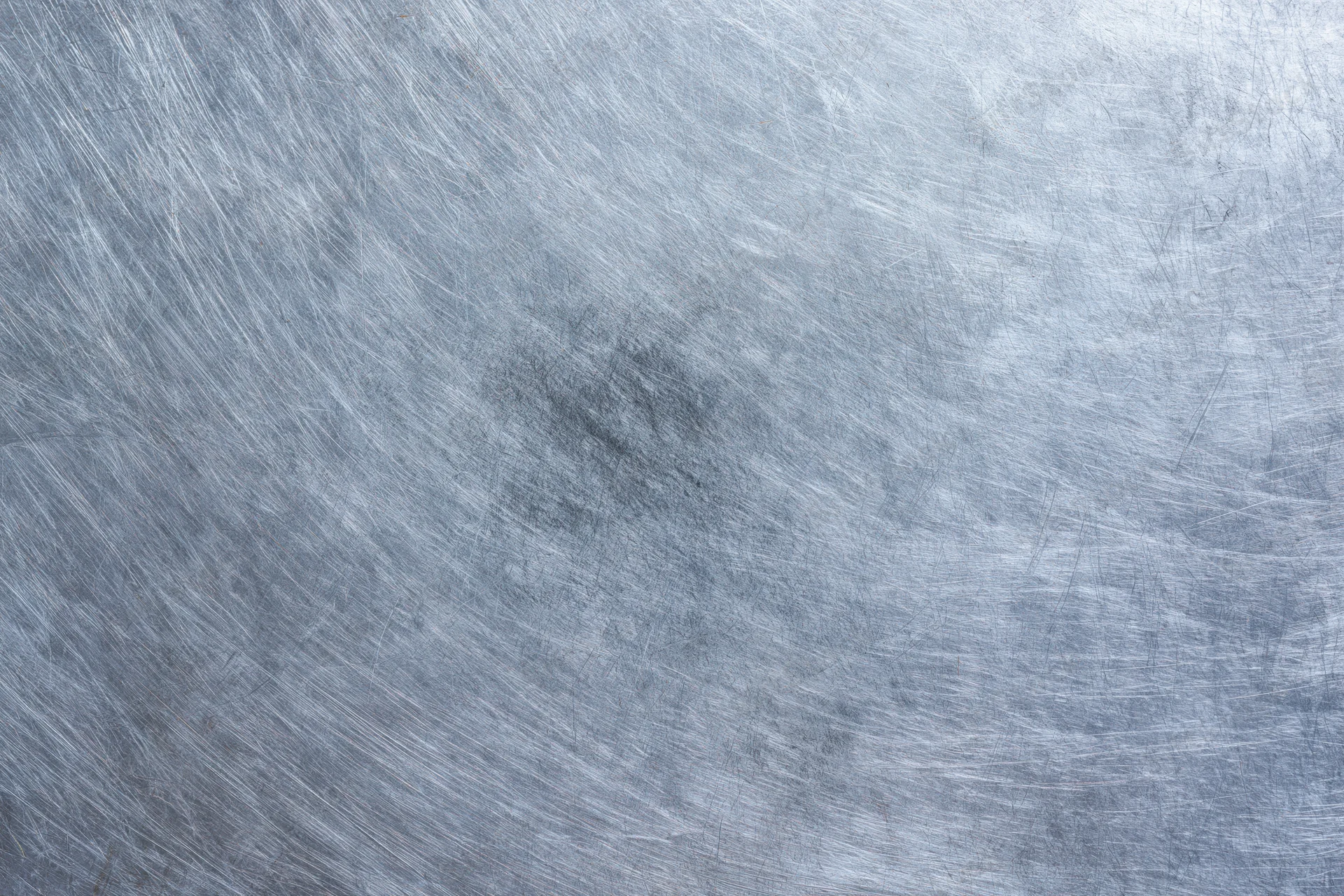 Flat worn metal surface covered in fine scratches and scuffs