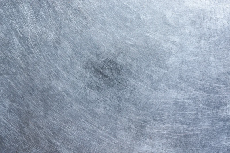 Flat worn metal surface covered in fine scratches and scuffs