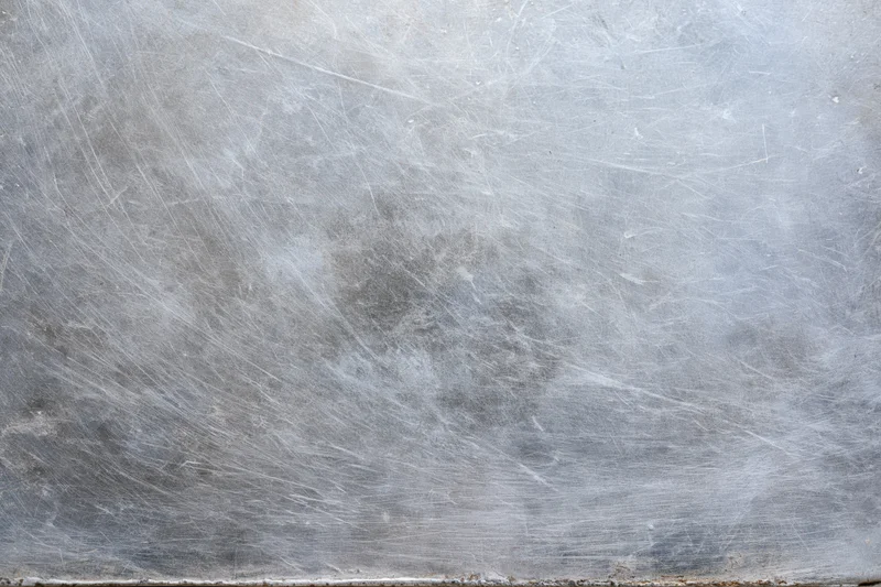 Worn metal surface covered in fine scratches and scuffs