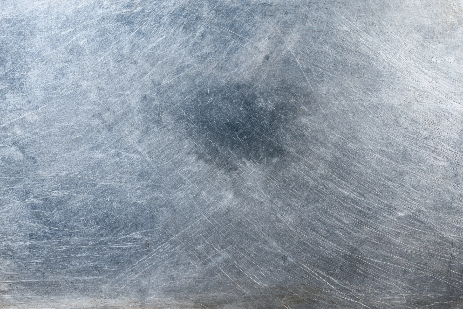 Worn metal surface covered in fine scratches and scuffs