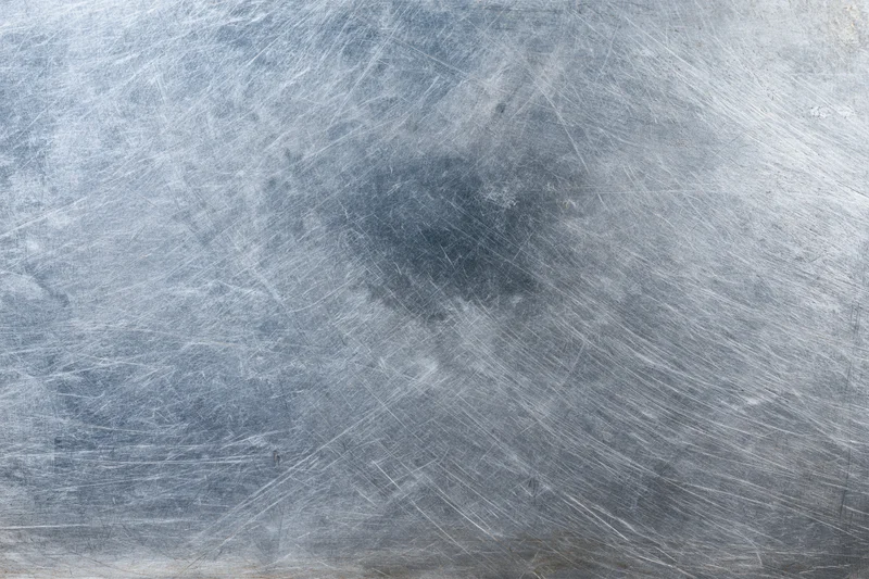 Worn metal surface covered in fine scratches and scuffs