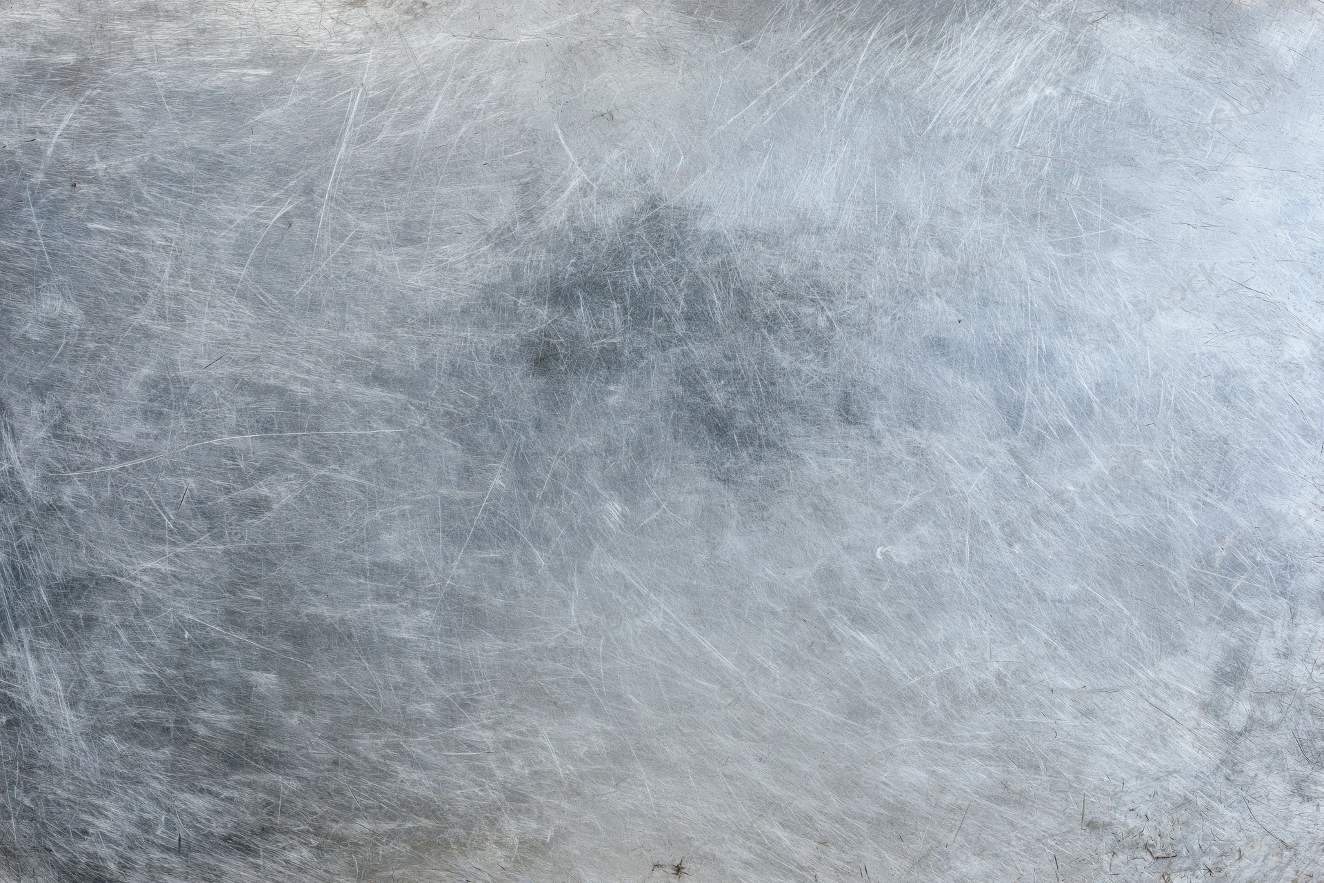 Worn metal surface covered in fine scratches and scuffs