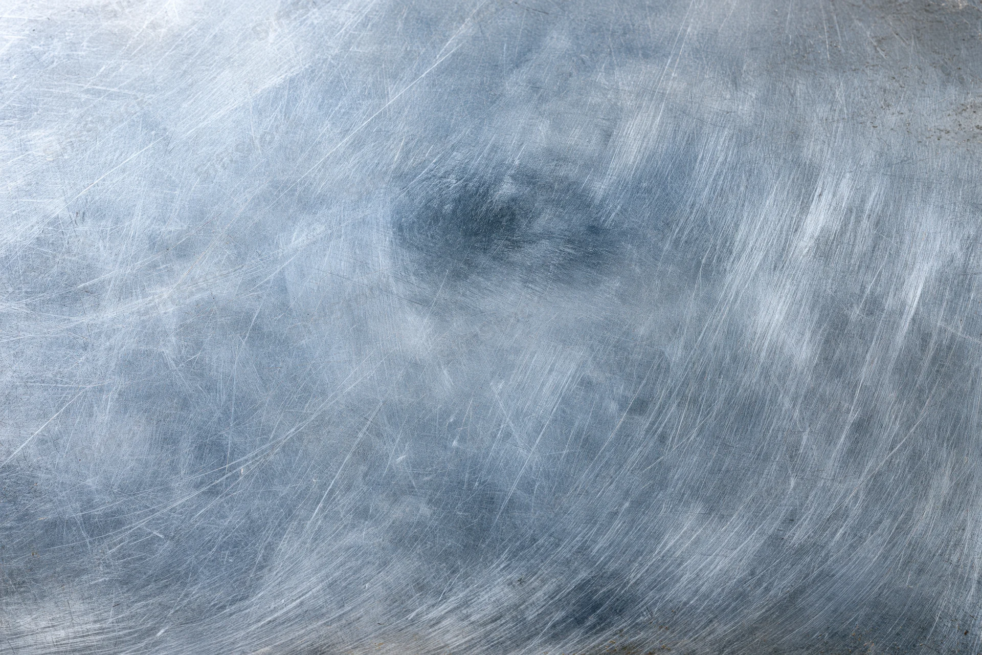 Worn metal surface covered in fine scratches and scuffs